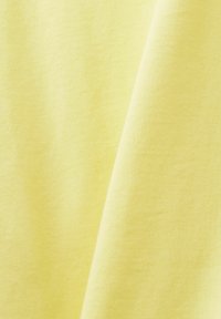 Tessuto morbido e leggero di un vivace colore giallo con una trama liscia, caratterizzato da una leggera lucentezza e una leggera caduta. Nessun motivo o accessorio.