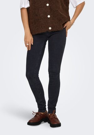 Mørk vask skinny jeans lavet af denim, parret med brune læder snørebåndssko med en tekstureret sål og rund tå.