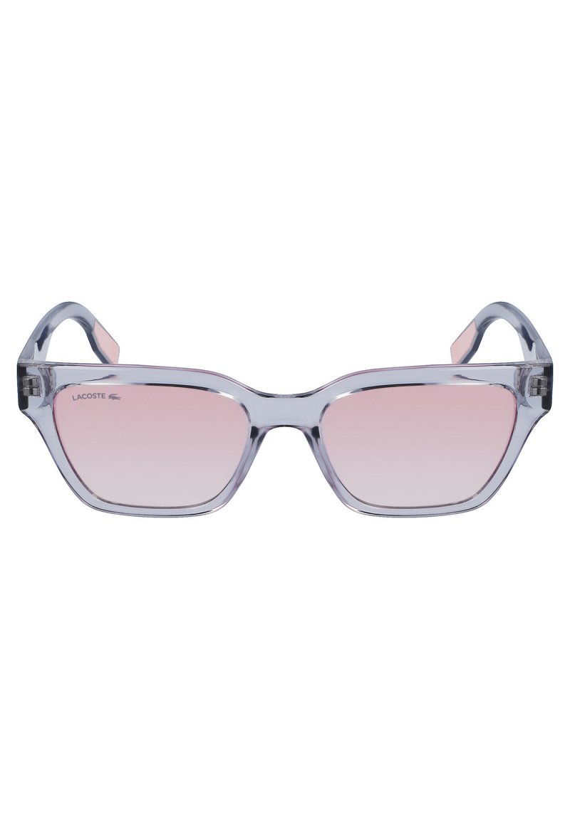Lunettes de soleil transparentes avec une monture géométrique, des verres dégradés roses et un logo Lacoste discret à l'avant. Construction en plastique léger.