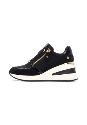 Zapatillas cuña negras con una combinación de texturas mate y charol, con herrajes dorados, un zipper lateral y una suela blanca acolchada.