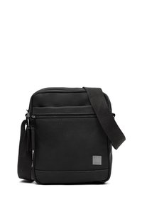 Čierna crossbody taška vyrobená z hladkého materiálu, s predným vreckom na zips a nastaviteľným popruhom. Minimalistický dizajn s jemným brandovaním.