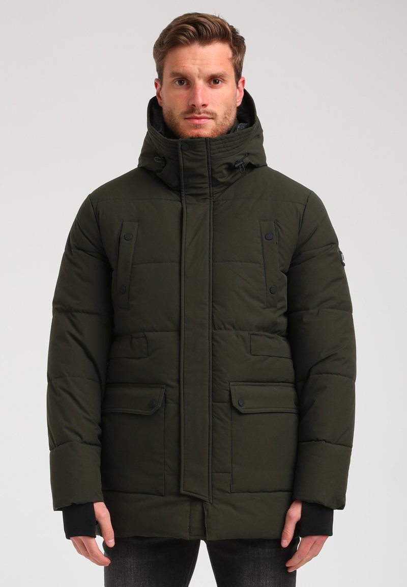Giacca parka imbottita verde con colletto alto, tasche anteriori con bottoni a pressione, cappuccio regolabile e polsini a costine. Texture liscia e design slanciato.