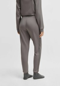 Gray jogger pants with a fitted design, elastic waistband, and textured side panel. Soft fabric and tapered legs enhance comfort and fit.