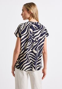 Short-sleeve top in navy with a white zebra stripe pattern, featuring a relaxed fit and soft texture, suitable for casual wear.