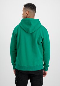Sudadera verde con bolsillo tipo canguro, puños y dobladillo acanalados. Tejido suave y corte relajado que brinda comodidad. Cuenta con una gran capucha ajustable.