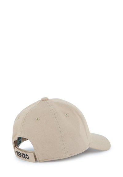 Casquette de baseball beige avec une visière courbée, un tissu texturé et une sangle velcro à l'arrière, ornée de "KENZO" brodé en noir.