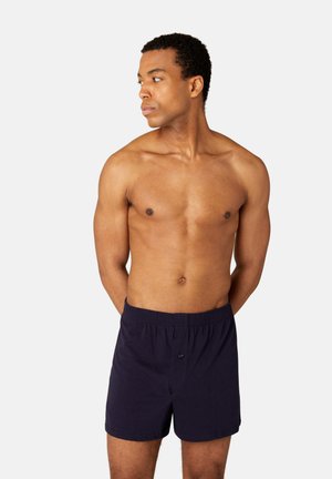 Navy blue boxer shorts with an elastic waistband and a front button. Fabric appears smooth with a simple design, no visible patterns.