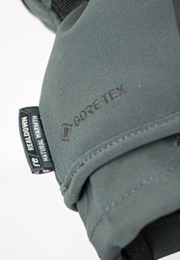 GORE-TEX-jacka i dämpad grön tyg. Har texturkontrast med en etikett som läser "REALDOWN" och "NATURAL WARMTH."