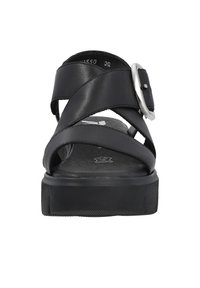 Sandal en cuir noir avec des brides entrecroisées et une boucle métallique. Semelle en caoutchouc épais avec un motif texturé pour l'accroche.