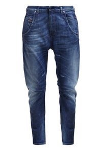 Tummansinisiä farkkuja, joissa on haalistunut kulutettu vaikutelma, kaventuva malli, viisi taskua ja kontrastiväriset tikkaukset. Sujuva pinta ja näkyvät saumat.