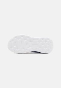 Semelle en caoutchouc blanche de chaussure de sport avec motif de bande de roulement, comportant des sections surélevées pour une meilleure adhérence et des formes courbées pour une flexibilité accrue.