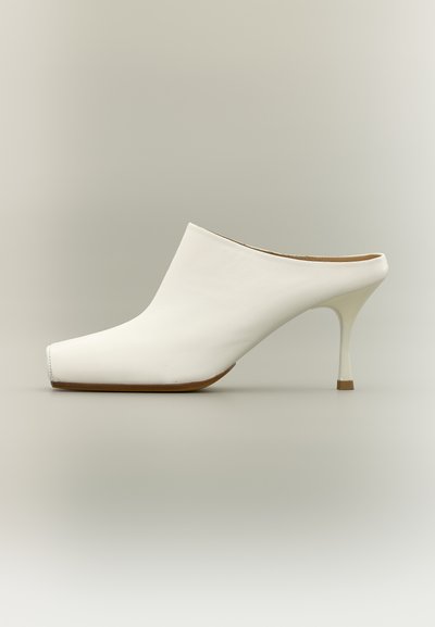 Λευκό δερμάτινο mule με τετράγωνη μύτη και λεπτό τακούνι στιλέτο μεσαίου ύψους σε ουδέτερο φόντο.
