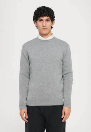 Grauer Strickpullover mit Rundhalsausschnitt und gerippten Bündchen sowie Saum, kombiniert mit einem darunter getragenen Kragenhemd. Schlichtes und sauberes Design.