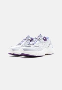 Αθλητικά παπούτσια σε ασημί χρώμα με μοβ λεπτομέρειες, με υφασμένο επάνω μέρος, στυλ κορδονιών και χοντρή λευκή σόλα με μοβ πέλμα.