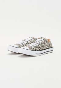 Platnene tenisice s uzorkom leopard, bijelim vezicama, gumeni zaštitni vrh i kontrastna crna traka duž đona. Lagane i s teksturiranom površinom.