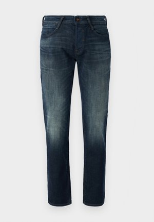 Jean en denim bleu foncé avec une coupe droite, présentant des zones décolorées, des poches avant et une fermeture à bouton. Pas d'embellissements ou de motifs visibles.