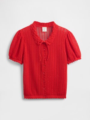 Red knitted blouse with short puff sleeves, scalloped collar, and button closure. Features open weave pattern and slightly textured fabric.