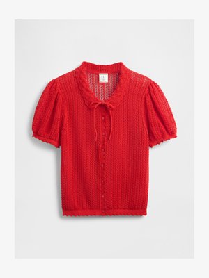 Blusa tricotata rossa con maniche corte a sbuffo, colletto scallop e chiusura con bottoni. Presenta un motivo a trama aperta e un tessuto leggermente testurizzato.