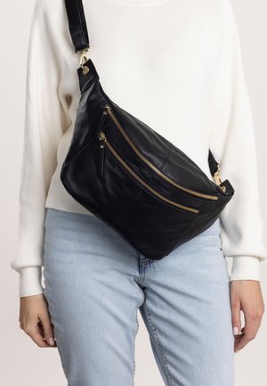 Black leather crossbody bag with two front zip pockets and a curved design. Features a gold-tone hardware and adjustable strap.