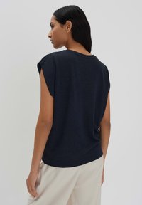 Haut bleu marine à manches courtes avec une texture douce, encolure ronde et coupe décontractée ; conçu avec un ourlet courant et des coutures minimales.