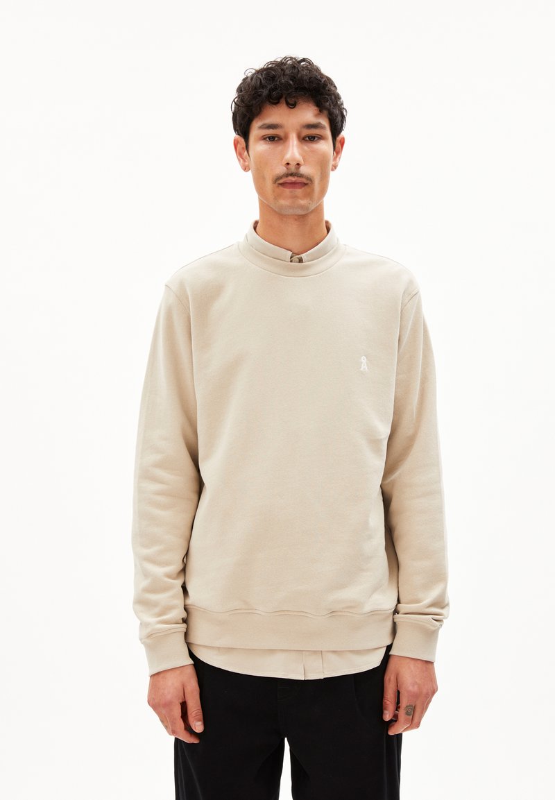 Helles beige Sweatshirt mit hohem Kragen, gerippten Bündchen und einem dezenten Logo auf der Brust. Hergestellt aus weichem, Baumwoll-Mischgewebe.