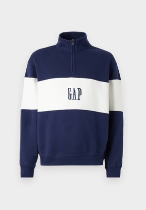 Navy blue pullover sweatshirt with white horizontal stripes, zip-up collar, and "GAP" logo in dark blue embroidered on the front.