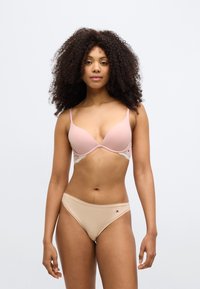 Lyserød BH med glatte skåle og blonderdetaljer, kombineret med beige højskårede trusser med et lille logo. Simpelt, tætsiddende design.