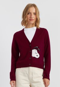 Bordeaux geklede cardigan met een v-hals en knopen aan de voorkant, met een gestructureerd Snoopy-ontwerp aan de linkerkant. Gemaakt van zachte stof.
