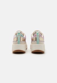 Baskets avec une finition crème et métallique, présentant un dos en textile multicolore, une semelle surélevée et des accents turquoise contrastants.