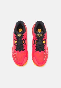 Scarpe da atletica di un vivace rosa con accenti neri, caratterizzate da una superficie texturizzata, robuste stringhe nere e dettagli con il logo sulla linguetta e sul lato.