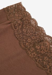 Bruine stof met een kantafwerking die bloemmotieven langs de rand heeft. De textuur is glad met delicate, ingewikkelde kantdetails.