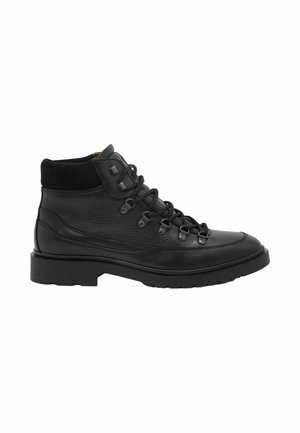 Bota negra de cuero con cordones hasta el tobillo, con cuello acolchado, ojales metálicos y suela con textura antideslizante, mostrada en perfil lateral sobre fondo blanco.