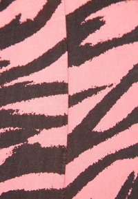 Tissu rose avec un motif de rayures zèbre noires, présentant une surface légèrement texturée et une couture centrale.