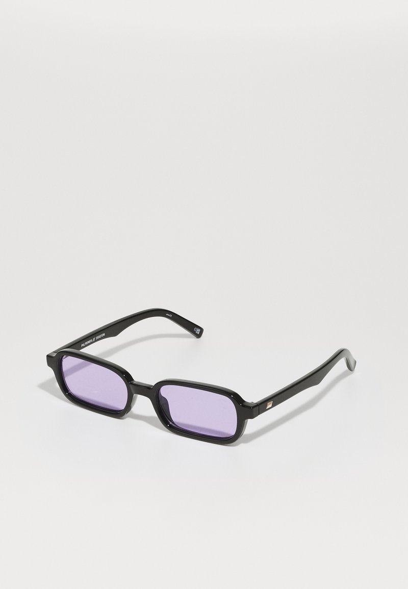 Gafas de sol rectangulares negras con lentes tintados de púrpura. Hechas de plástico, con un acabado brillante y patas delgadas negras con acentos dorados.