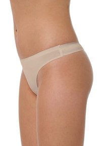 Culotte en thong nude avec un design taille basse, bords sans couture et un matériau doux et extensible pour un ajustement confortable.
