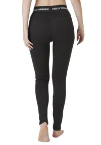 Leggings negros de material elástico con una cinturilla ancha que presenta el logo "HELLY HANSEN". Textura suave, diseño ajustado.