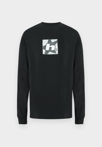 Μαύρη μπλούζα με μακριά μανίκια και λαιμόκομμα, που διαθέτει μια κεντρική γκρι τετράγωνη σχεδίαση με ένα αστέρι και ένα στυλιζαρισμένο λευκό λογότυπο με το γράμμα "h".