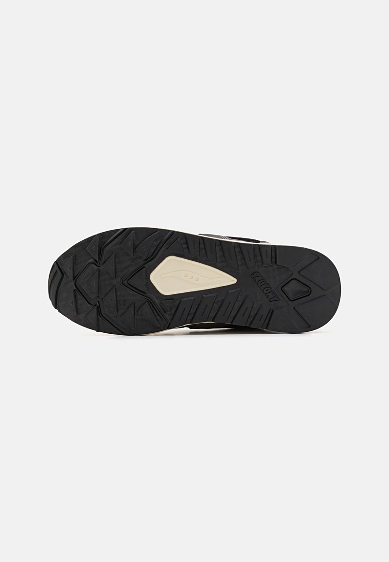 Suola di scarpa in gomma nera con motivo di trama testurizzata. Presenta accenti di colore chiaro e un design robusto per una trazione su diverse superfici.
