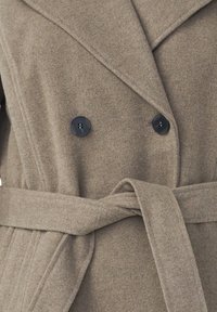 Taupe ull dubbelsidig kappa med två svarta knappar och ett matchande tygbälte knutet i midjan.