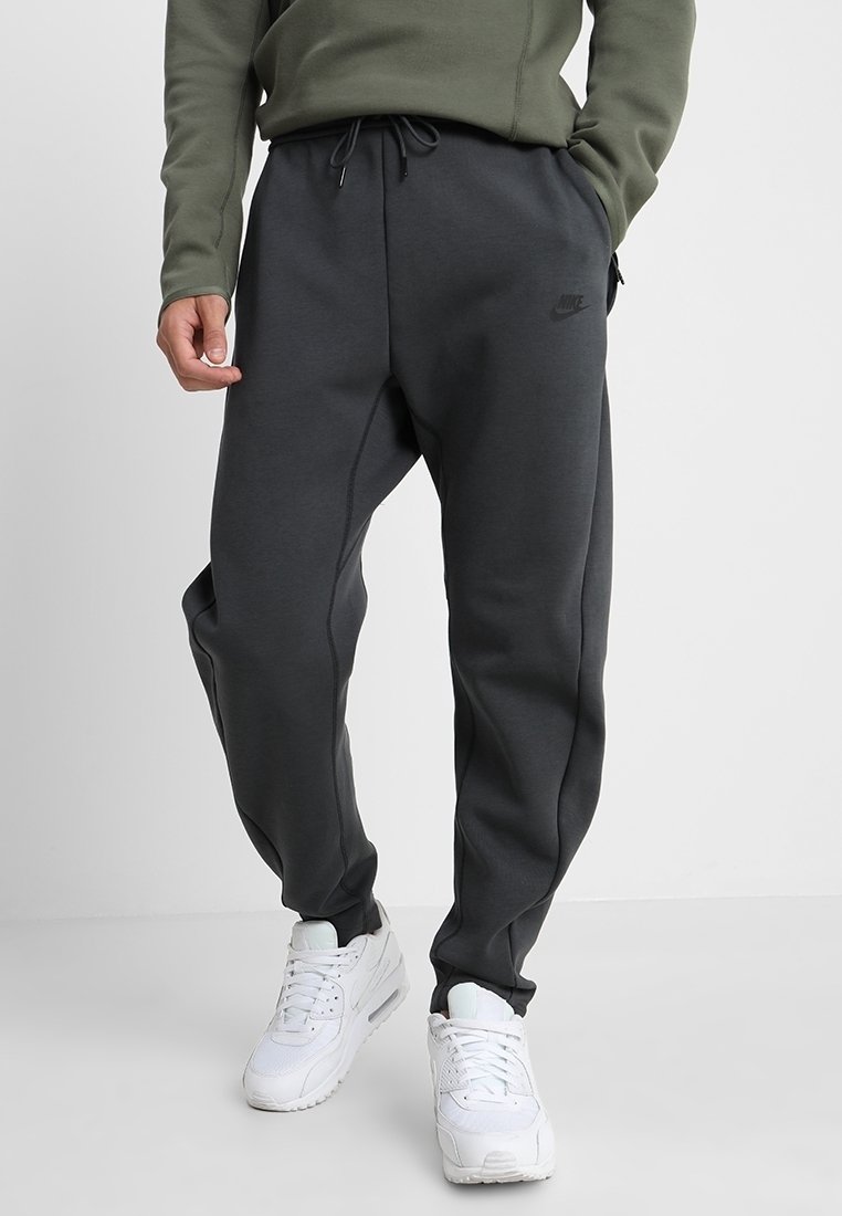 Mörkgrå bomullsbyxor med avsmalnande ben och elastisk midja. Har sidfickor och en subtil logotyp. Kombineras med vita sneakers.