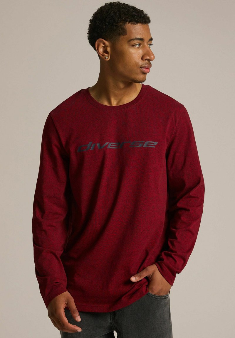 Czerwona koszulka z długim rękawem wykonana z mieszanki bawełny, z okrągłym dekoltem i szarym graficznym logo "diverse" na piersi.