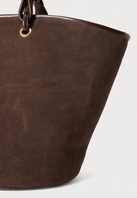 Brown suede tote bag with a wide, slouchy shape, featuring a glossy brown leather trim and a gold-tone eyelet detail for the handle.
