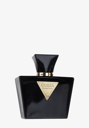 Mustan kiiltävä kolmionmuotoinen hajustepullo, jossa on leveä, kulmikas korkki ja kullanvärinen etiketti, jossa lukee edessä "GUESS Seductive".