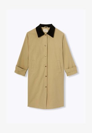 Manteau marron clair avec un col en velours côtelé noir, comportant un devant à boutons, deux poches latérales et des manches retroussées. Texture de tissu lisse.