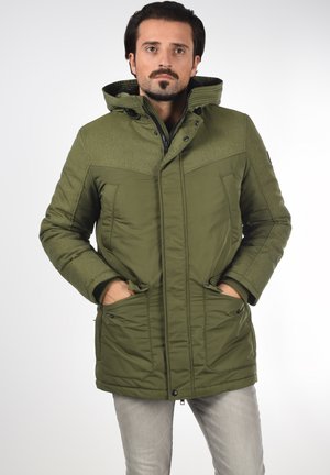 Grüne Parka-Jacke mit strukturiertem oberen Abschnitt, zwei Fronttaschen und Kapuze. Verfügt über einen Reißverschluss und sichtbare Nähdetails.