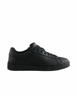 Lage zwarte leren sneaker met zwarte veters en rubberen zool, zijaanzicht op een witte achtergrond.