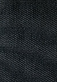 Tissu texturé d'un bleu marine profond avec un motif géométrique subtil ; tissage lisse et dense, adapté à l'ameublement ou à l'habillement.