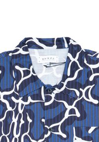 Camicia a maniche corte con un motivo astratto blu e bianco. Realizzata in tessuto leggero con strisce verticali e colletto button-down.