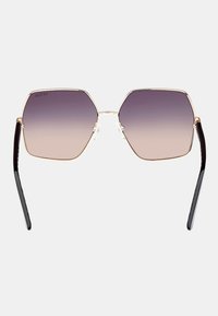 Ochelari de soare hexagonali cu lentile degradate de culoare violet, ramă din metal aurit și culise elegante negre. Include pad-uri pentru nas pentru confort.