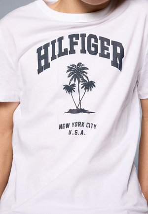 Camiseta blanca con texto negro "HILFIGER" sobre un gráfico de palmera y "NEW YORK CITY U.S.A." impreso debajo de los árboles.